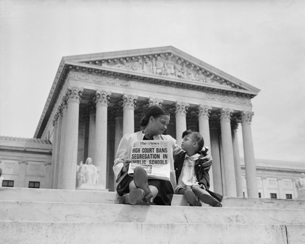 Nettie Hunt and her daughter Nickie on the steps of the United States Supreme Court, May 1954, holding a newspaper headlined "High Court Bans Segregation in Public Schools"